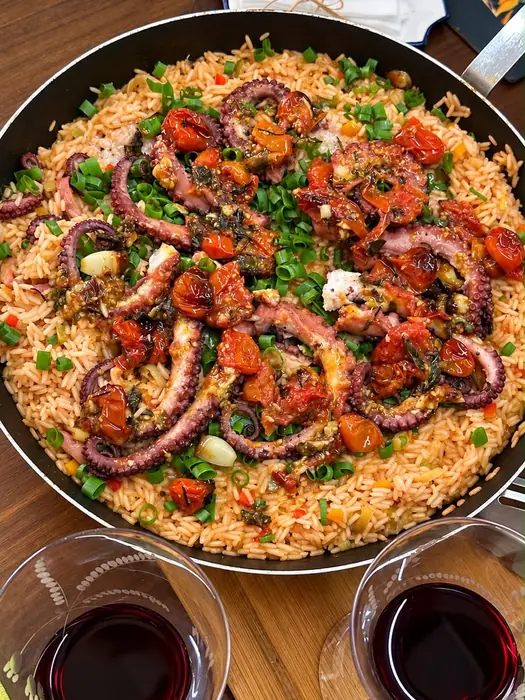 Panela de arroz de polvo servida no centro da mesa